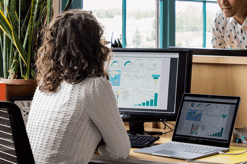 women on chair looking at Power BI Dashboard